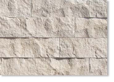 Beige textured stone wall with rectangular blocks and visible mortar lines.