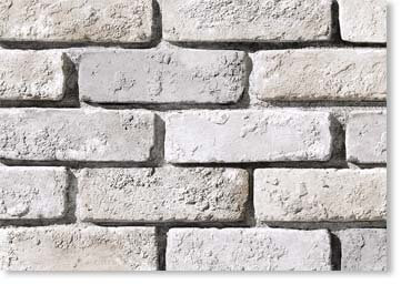 Close-up of a light gray brick wall with rough, textured bricks and visible mortar lines.