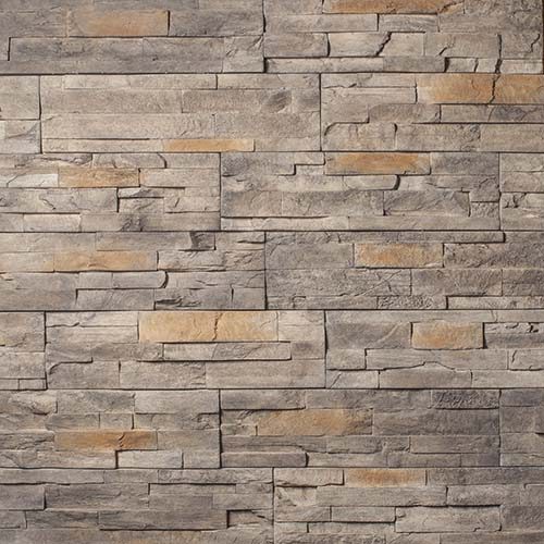 Gray and tan stacked stone wall with rectangular bricks creating a textured surface used as exterior siding or interior accent wall.