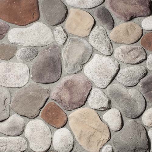 Close-up of smooth, multicolored pebbles in gray, beige, brown, and white.