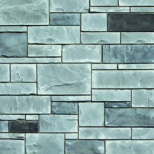 Bluish-gray stone wall with rectangular blocks in a staggered pattern during daylight.