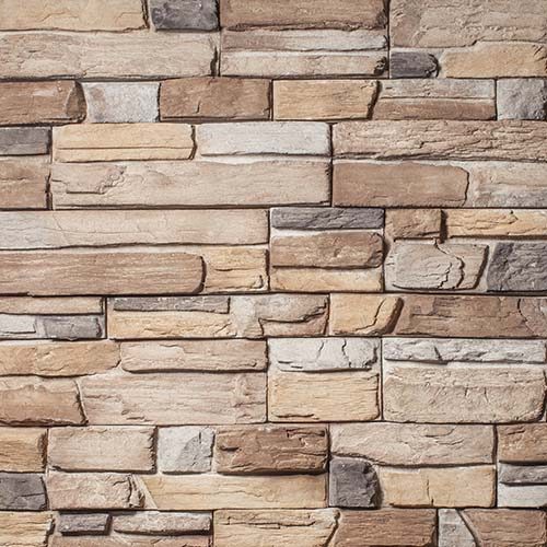 Close-up of a stacked stone veneer wall with rectangular tan, brown, and gray stones.