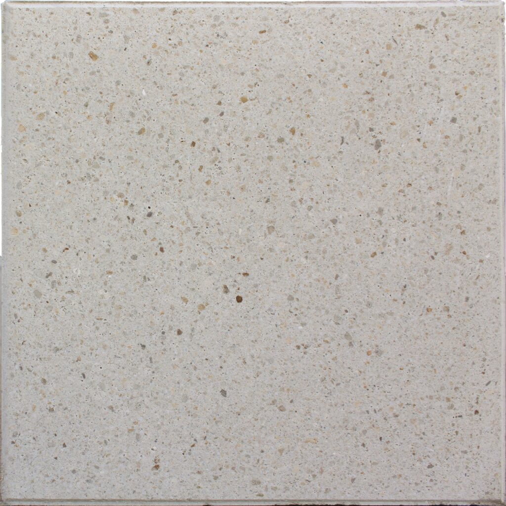 Light beige terrazzo tile with small brown and gray flecks, close-up texture pattern.